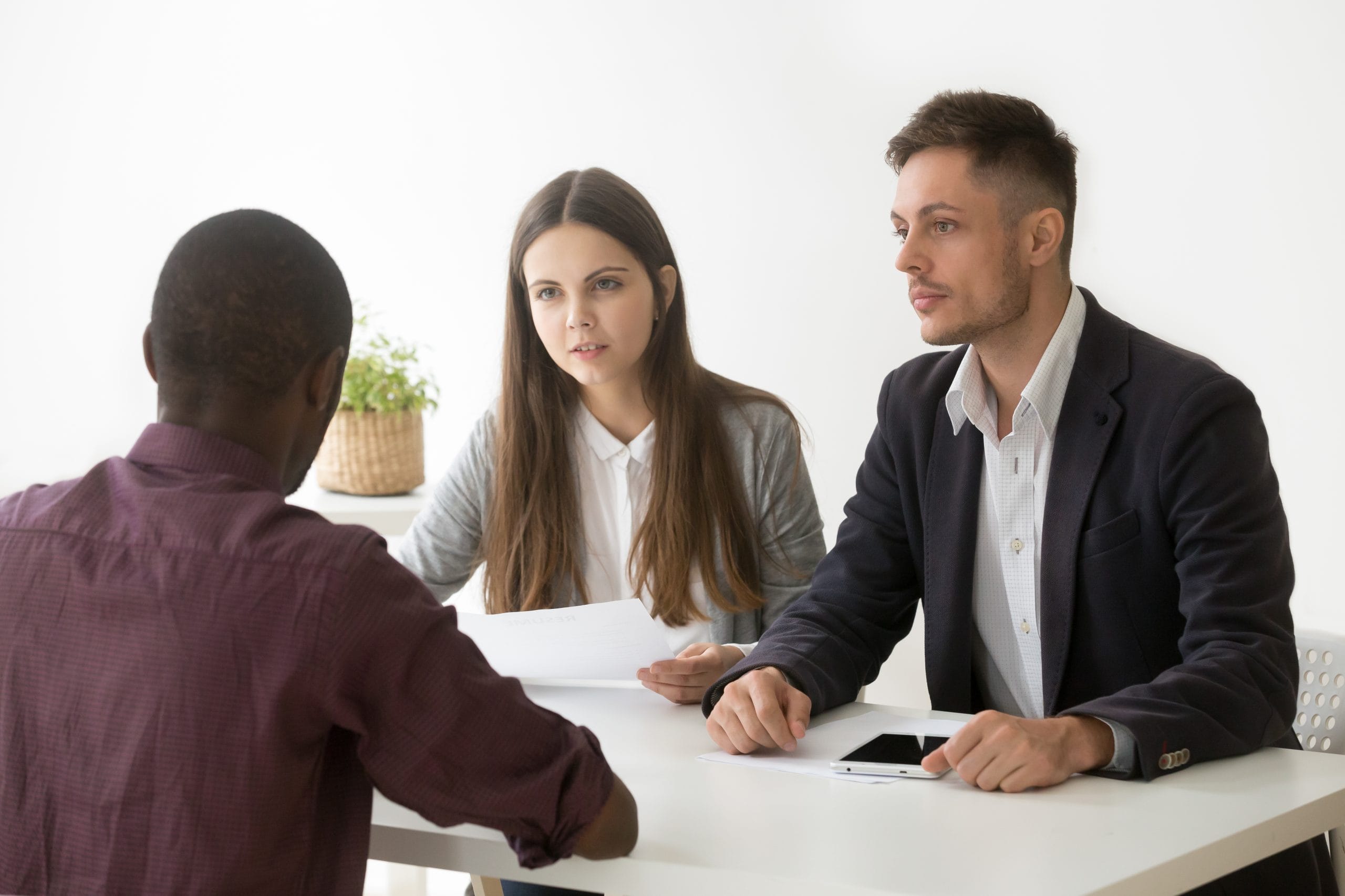 Serious hr managers listen to african applicant at job interview